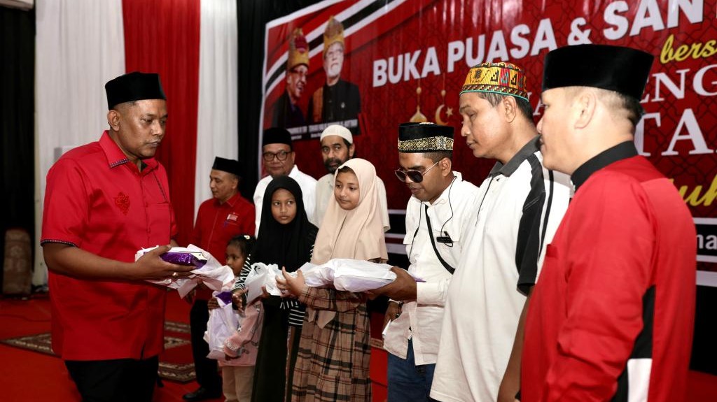 Ketua DPR Aceh memberikan bingkisan kepada abak yatim dan disabilitas. 