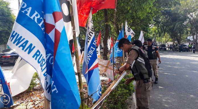 Bendera partai hingga baliho calon anggota legislatif (caleg) di median Jalan T Nyak Makam, Kota Banda Aceh, dibongkar Panitia Pengawas Pemilihan (Panwaslih) bersama Satuan Polisi Pamong Praja, Senin (15/1/2024). Foto: Habil Razali/acehkini