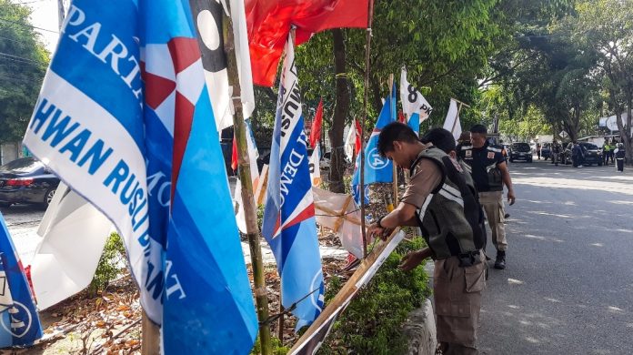 Bendera partai hingga baliho calon anggota legislatif (caleg) di median Jalan T Nyak Makam, Kota Banda Aceh, dibongkar Panitia Pengawas Pemilihan (Panwaslih) bersama Satuan Polisi Pamong Praja, Senin (15/1/2024). Foto: Habil Razali/acehkini