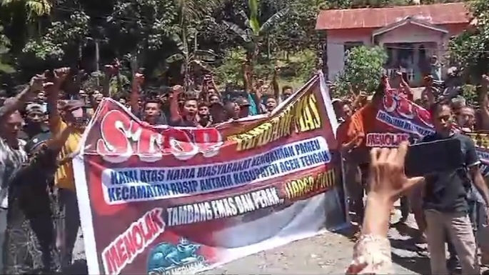 Warga Kemukiman Pameu, Rusip Antara, Aceh Tengah, Aceh, menolak rencana masuknya perusahaan tambang emas dan mineral ikutan ke wilayah itu. Mereka membentangkan spanduk berisi pesan penolakan pada Selasa (22/10/2024).